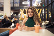 © Mosuno/Stocksy - Young Woman sitting in a Food Court of Shopping Mall