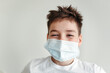 © Irina Polonina/Stocksy - A young boy in a protective medical mask.