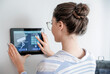 © Pixel-Shot - Woman using smart home security system control panel