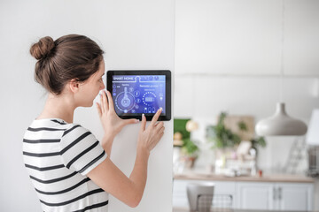 Woman using smart home security system control panel