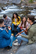 © Bisual Studio/Stocksy - Friends doing picnic and playing guitar outdoors