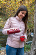 © Bisual Studio/Stocksy - Woman preparing a hot drink at nature on autumn day