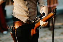Close Up Of A Cowboy Holding A Big Gun In His Hands And Loading It