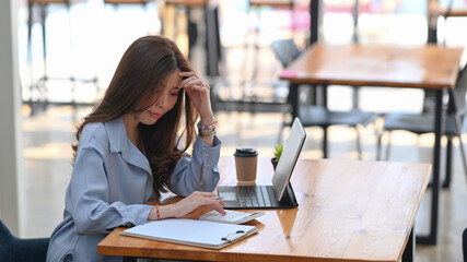 Wall Mural - Young female accountant using calculator for calculate financial report and working with computer tablet at office.