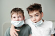 © Irina Polonina/Stocksy - Young brothers in protective medical masks.