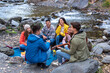 © Bisual Studio/Stocksy - Friends doing picnic and playing guitar outdoors