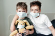 © Irina Polonina/Stocksy - Young brothers in protective medical masks.
