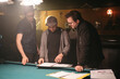 © Mindy Dunlap/Stocksy - A film crew reviews a script before filming