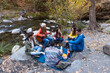 © Bisual Studio/Stocksy - Friends doing picnic and playing guitar outdoors