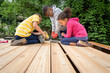 © Jennifer Bogle/Stocksy - Siblings building a deck