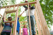 © Jennifer Bogle/Stocksy - Boy hands screw to his father as they build playhouse