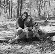 © Jakob Lagerstedt/Stocksy - Mother and her two children sitting on a fallen tree in the woods