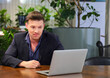 © Akarawut - Caucasian businessman is using video call while working in green eco friendly modern working space surrounded by air purifying house plant