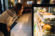 © Vradiy Art/Stocksy - Woman choosing desserts in bakery