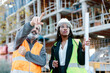 © Jimena Roquero/Stocksy - Construction worker talking with woman engineer in front of a construction area