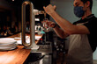 © Javier Pardina/Stocksy - Bartender serving draft beer