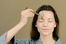 Tender Woman Applying Jade Roller On Skin