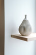 © Melissa Milis Photography/Stocksy - Modern white vase on a wooden shelf