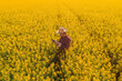 Aerial view of oilseed rape farmer using drone remote controller