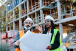 © Jimena Roquero/Stocksy - Woman engineer giving instructions to construction worker based on blueprints.