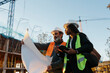 © Jimena Roquero/Stocksy - Woman engineer supervising construction of building with construction worker at sunset.