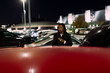 © Jimena Roquero/Stocksy - Candid shot of young attractive woman in a car parking lot