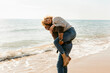 © Valentina Barreto/Stocksy - Happy couple piggyback at the beach