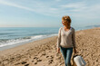 © Valentina Barreto/Stocksy - mature woman walking on the beach