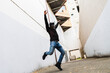 © Guaita Studio/Stocksy - Young urban man dancing in the middle of an alley in city
