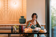 © Studio Firma/Stocksy - An Asian Woman in a Restaurant