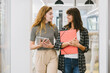 © MyMicrostock/Stocksy - Two businesswomen talking in an office