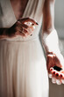 © Melissa Milis Photography/Stocksy - closeup of bride spraying perfume while sun hits her fragile skin