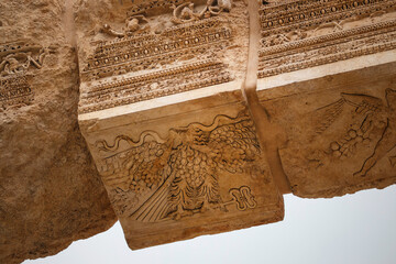 Wall Mural - Cupid figure and an eagle holding a herald's staff carved at the entrance of Bacchus temple, Heliopolis Roman ruins, Baalbek, Lebanon