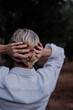 © Eloisa Ramos/Stocksy - Close-up of Senior woman from back holding her white hair with hands