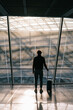 © Alina Hvostikova/Stocksy - Anonymous traveler standing near window in airport