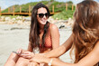 © Ivan Gener/Stocksy - Friends hanging out on a sandy beach