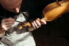 A Violin Artisan In His Workshop.