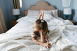 © Irina Polonina/Stocksy - A young girl is lying on the bed.