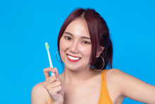 Beauty Portrait Young Asian Woman Holding Toothbrush And Smiling On Blue Background. Concept Good Oral And Dental Health.