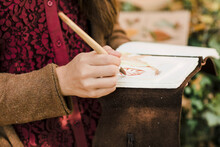 Closeup Of A Young Woman Painting A Leaf
