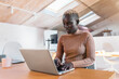 © Nunez Image/Stocksy - Afro Woman Working in Office