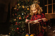 © Julie Meme/Stocksy - Little blonde girl opens a new year gift