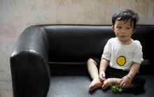 Cute Asian Little Boy Eating Grapes