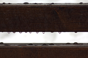 water drops on the wooden back of the bench after the rain