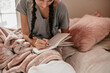 © Léa Jones/Stocksy - young woman journaling in her bedroom