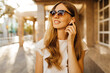 © Shopping King Louie - young woman listening to music through wireless headphones outdoors in the city