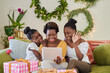 © Juno/Stocksy - Mother and daughters video calling with family at Christmas