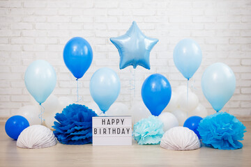 Wall Mural - birthday party decoration - air balloons, paper balls and lightbox with happy birtday text over brick wall