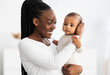 © Prostock-studio - African American mom hugging her cute baby at home