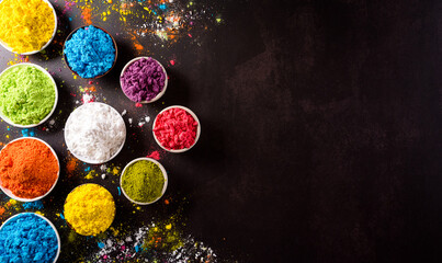 Happy holi festival decoration.Top view of colorful holi powder on dark background with copy space for text.